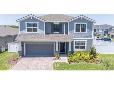 Two story home with gray siding, two car garage and landscaping at 7904 Waterfield Ave # 1, Orlando, FL 32832