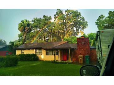 Charming ranch home with brick accents, a red door and a lush green yard at 225 Se 30Th Ave, Ocala, FL 34471