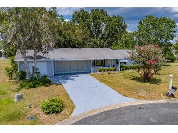 Single story home with a two-car garage and a landscaped yard at 17775 Se 101St Ct, Summerfield, FL 34491