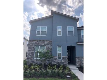 Two-story home with gray siding and stone accents at 2178 Cooper Bell Pl, Kissimmee, FL 34747