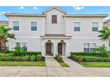 Two-story townhome with light gray siding and two-car driveway at 8984 Stinger Dr, Champions Gate, FL 33896