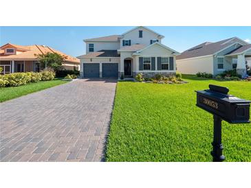 Two-story house with gray-toned garage doors and a brick driveway at 30053 Island Club Dr, Tavares, FL 32778