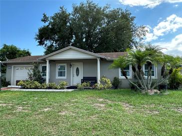 House exterior with a lawn, palm trees, and a two-car garage at 809 Florida Pkwy, Kissimmee, FL 34743