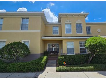 Two-story townhome with light yellow exterior and a welcoming porch at 5434 River Rock Rd, Lakeland, FL 33809