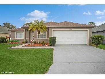 One-story home with a neutral color palette, attached garage and well-maintained lawn at 218 Hillcrest Dr, Davenport, FL 33897