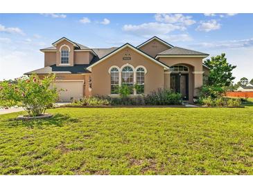 Two-story house with a large front yard, two-car garage, and landscaping at 20606 Quinn St, Orlando, FL 32833
