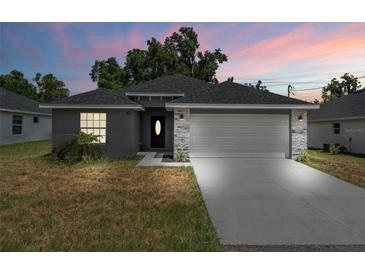 Modern two-car garage home with stone accents at 43 S Kentucky Ave, Umatilla, FL 32784