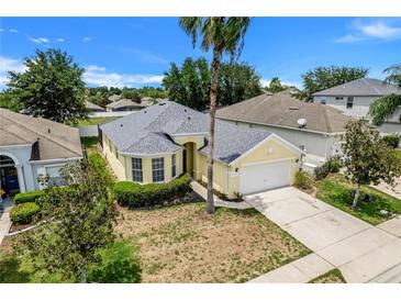 One-story house with a yellow exterior, grey roof, and attached garage, seen from above at 618 Copeland Dr, Haines City, FL 33844