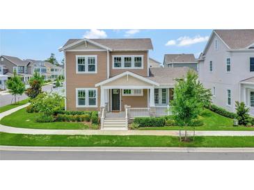 Two-story craftsman style home with front porch and landscaping at 7540 Estuary Lake Loop, Celebration, FL 34747
