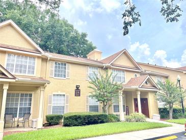 Tan two-story townhome with manicured lawn at 837 Grand Regency Pt # 207, Altamonte Springs, FL 32714