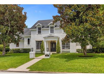 Two story house with white brick exterior, manicured lawn, and walkway at 2234 Via Luna, Winter Park, FL 32789