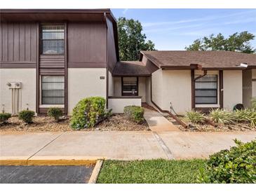 Two-story condo building with brown siding and paved walkway at 225 Terrace Hill Blvd # 1C, Debary, FL 32713