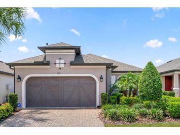 Single-story house with a brown garage door and landscaping at 1282 Zeek Ridge St, Clermont, FL 34715