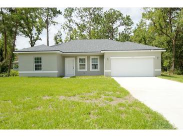 Single-story house with a two-car garage and well-maintained lawn at 6952 Sw 152Nd St, Ocala, FL 34473