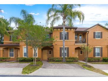 Townhouse with orange exterior and lush landscaping at 244 Capri Dr, Davenport, FL 33897