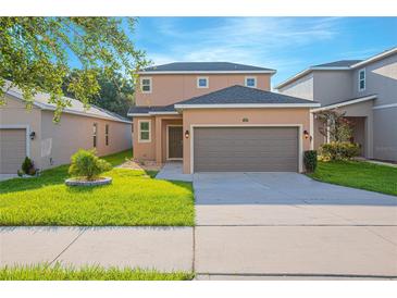 Two-story house with brown garage door and landscaping at 1146 Atlantic Ave, Fruitland Park, FL 34731