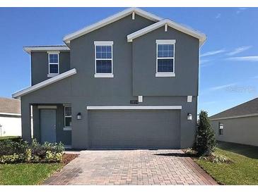 Two-story home with gray siding, two-car garage, and landscaped yard at 2854 Black Birch Dr, Ocoee, FL 34761