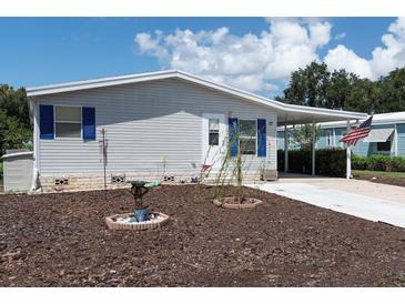 Exterior view of a manufactured home with landscaped yard and American flag at 550 Saint Johns Rd, Tavares, FL 32778
