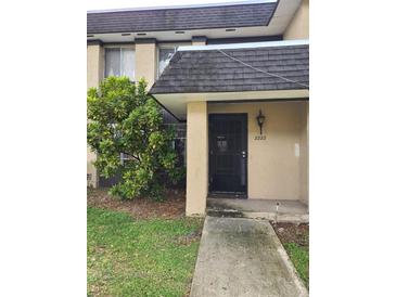Condo building exterior featuring a walkway and landscaping at 2222 Silver Pines Pl # 902, Orlando, FL 32808