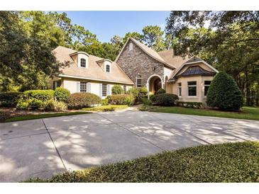 Two-story home with stone accents, landscaped yard, and a large driveway at 1750 Taylor Woods Rd, Deland, FL 32724
