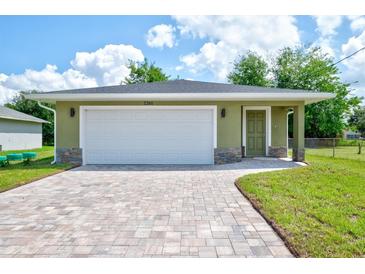 New construction home with a green exterior, white garage door, and paved driveway at 2261 Greenway St, Sanford, FL 32771