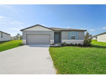 One-story home with gray siding, light-colored trim, and a two-car garage at 1717 Forest Run Ln, Auburndale, FL 33823