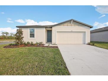 Single-story home with a two-car garage and landscaped lawn at 1752 Forest Run Ln, Auburndale, FL 33823