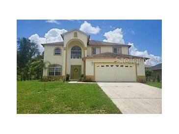 Two-story house with a large yard and two-car garage at 306 Athabasca Pl, Kissimmee, FL 34759