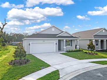 Modern house exterior with a two-car garage and landscaping at 506 Ellie Ct, Apopka, FL 32703