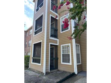 Tan 3-story building with balconies and lush landscaping at 4301 Lizshire Ln # C-109, Orlando, FL 32822