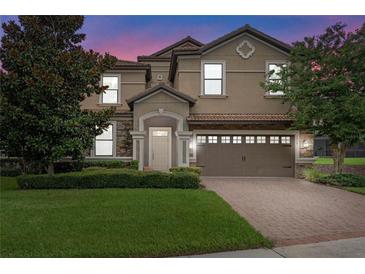 Two-story house with a tan exterior, brown garage door, and manicured lawn at 1424 Rolling Fairway Dr, Davenport, FL 33896