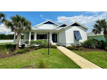 Charming white house with blue shutters at 1077 Sugar Loaf Key Loop, Lady Lake, FL 32159