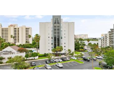 Aerial view of waterfront condo building with parking and pool at 6165 Carrier Dr # 1214, Orlando, FL 32819