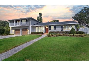 Two-story home with gray brick, updated garage doors, and a paved walkway at 515 N Boyd St, Winter Garden, FL 34787