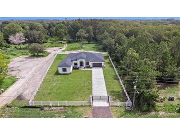 Stunning aerial view of a modern farmhouse with fenced yard at 3429 Boggy Creek Rd, Kissimmee, FL 34744
