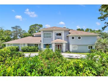 Two-story house with a circular driveway and lush landscaping at 9 Stone Gate N, Longwood, FL 32779