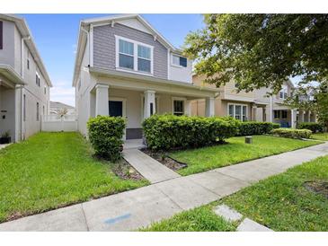 Two-story house with gray siding and a green lawn at 11109 Folklore St, Winter Garden, FL 34787
