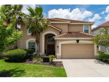 Two-story house with tan exterior, brown roof, and a two-car garage at 5237 Oakbourne Ave, Davenport, FL 33837