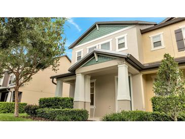 Two-story townhome with light beige and green exterior at 5102 Caspian St, Saint Cloud, FL 34771