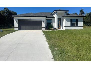 Modern home with gray garage door and green lawn at 14954 Sw 38Th Cir, Ocala, FL 34473