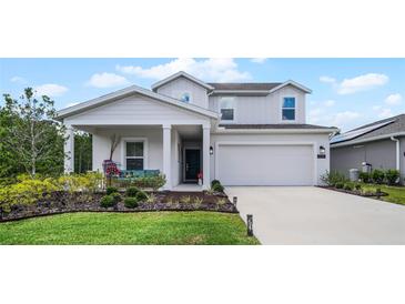 Two-story house with a front porch, driveway, and landscaping at 1105 Pacific Dunes Ct, Daytona Beach, FL 32124