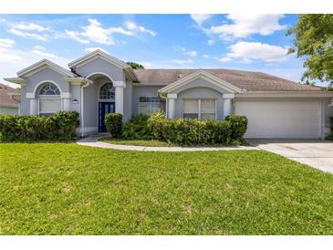 One story home with gray siding, two car garage and lush lawn at 12337 Greco Dr, Orlando, FL 32824