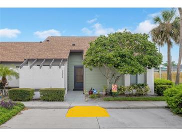 Single-story condo with a light green exterior, and a well-maintained front yard at 2384 Sun Valley Cir, Winter Park, FL 32792