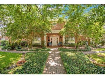 Brick home with lush landscaping and inviting front porch at 1650 Lakehurst Ave, Winter Park, FL 32789