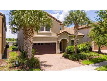 Two-story house with a brown garage door and palm trees at 8841 Rhodes St, Kissimmee, FL 34747