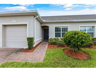 Exterior view of a charming villa with a brick pathway and well-manicured lawn at 2877 Attwater Loop, Winter Haven, FL 33884