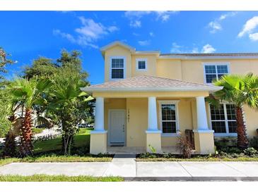 Two-story townhome with yellow exterior, white columns, and front porch at 17401 Serenidad Blvd, Clermont, FL 34714