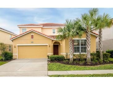 Two story house with a two car garage and landscaping at 6047 Broad Oak Dr, Davenport, FL 33837