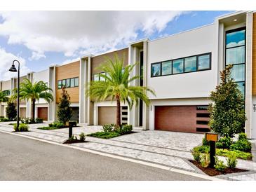 Modern townhouses with attached garages and landscaped yards at 986 Excellence Cir, Ocoee, FL 34761