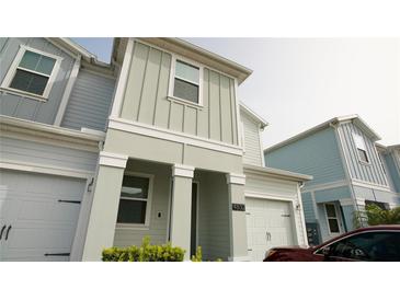 Two-story townhome with light green siding and attached garage at 4832 Tribute Trl, Kissimmee, FL 34746